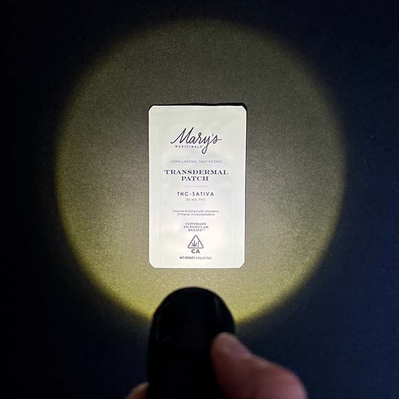 Mary's Medicinals Transdermal Patch being illuminated with a flashlight